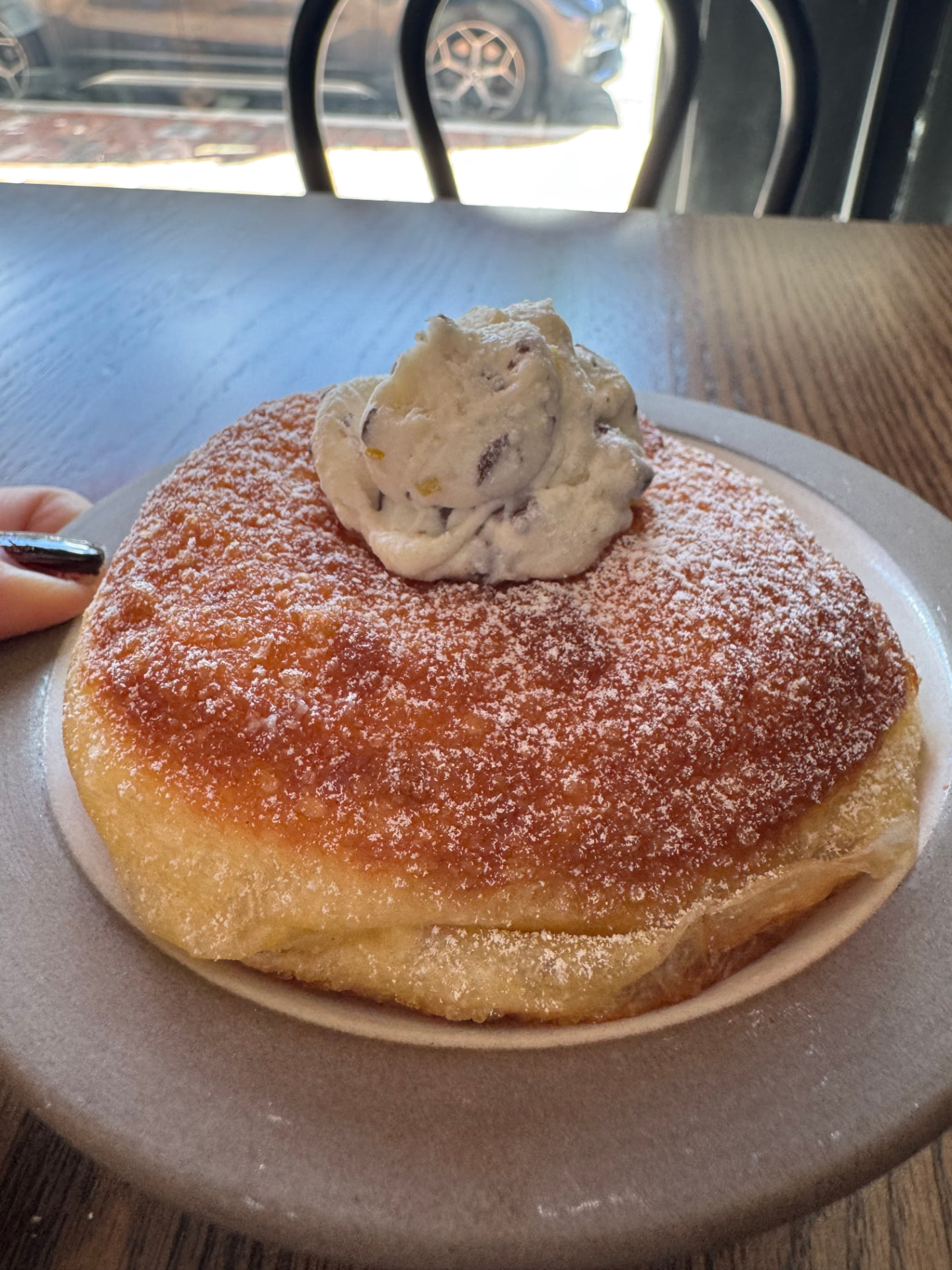 Jennifer’s golden bombolone dusted with powdered sugar and topped with cream at Pollara