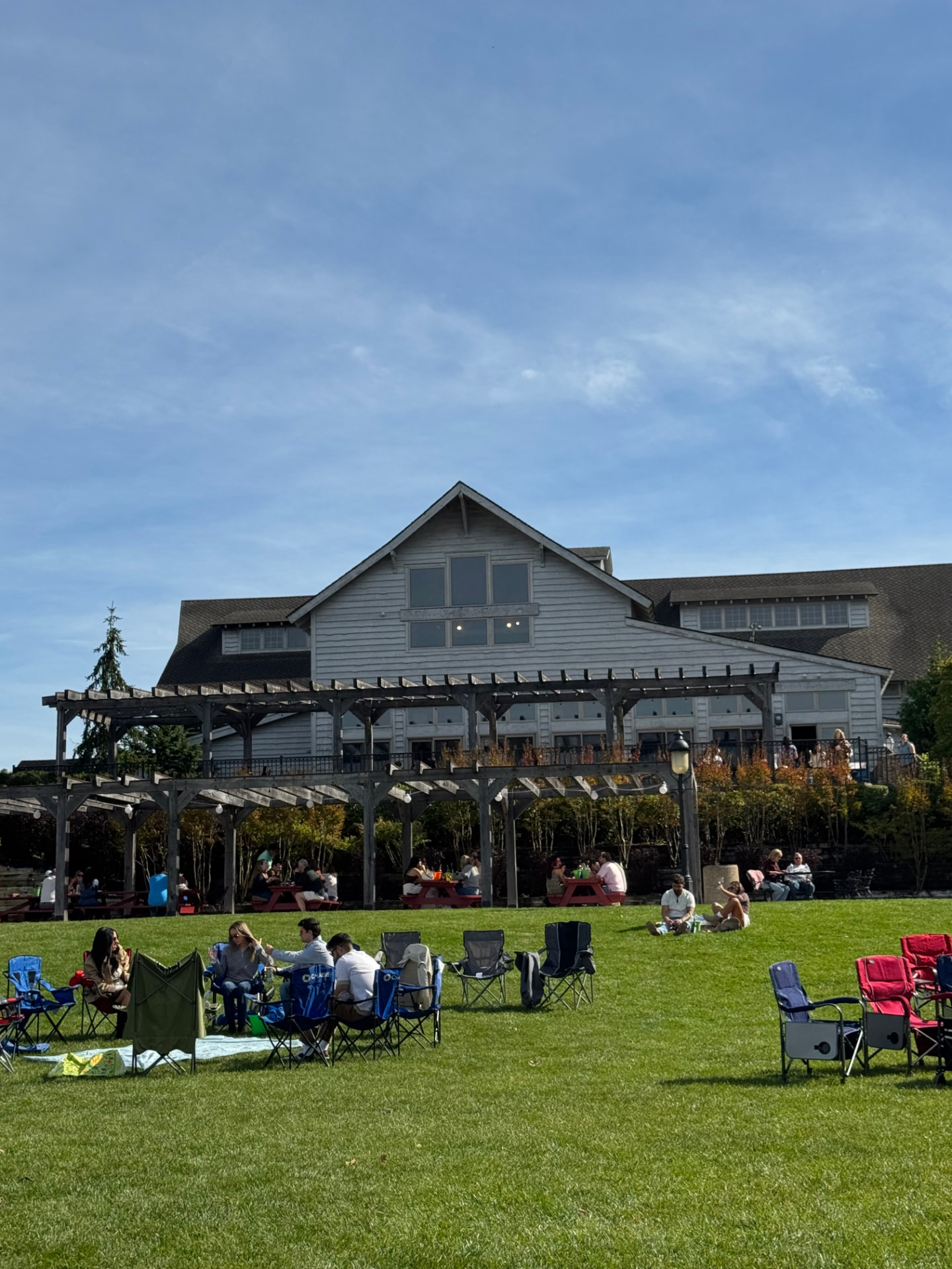 Visitors relaxing in chairs on the lawn in front of Laurita Winery
