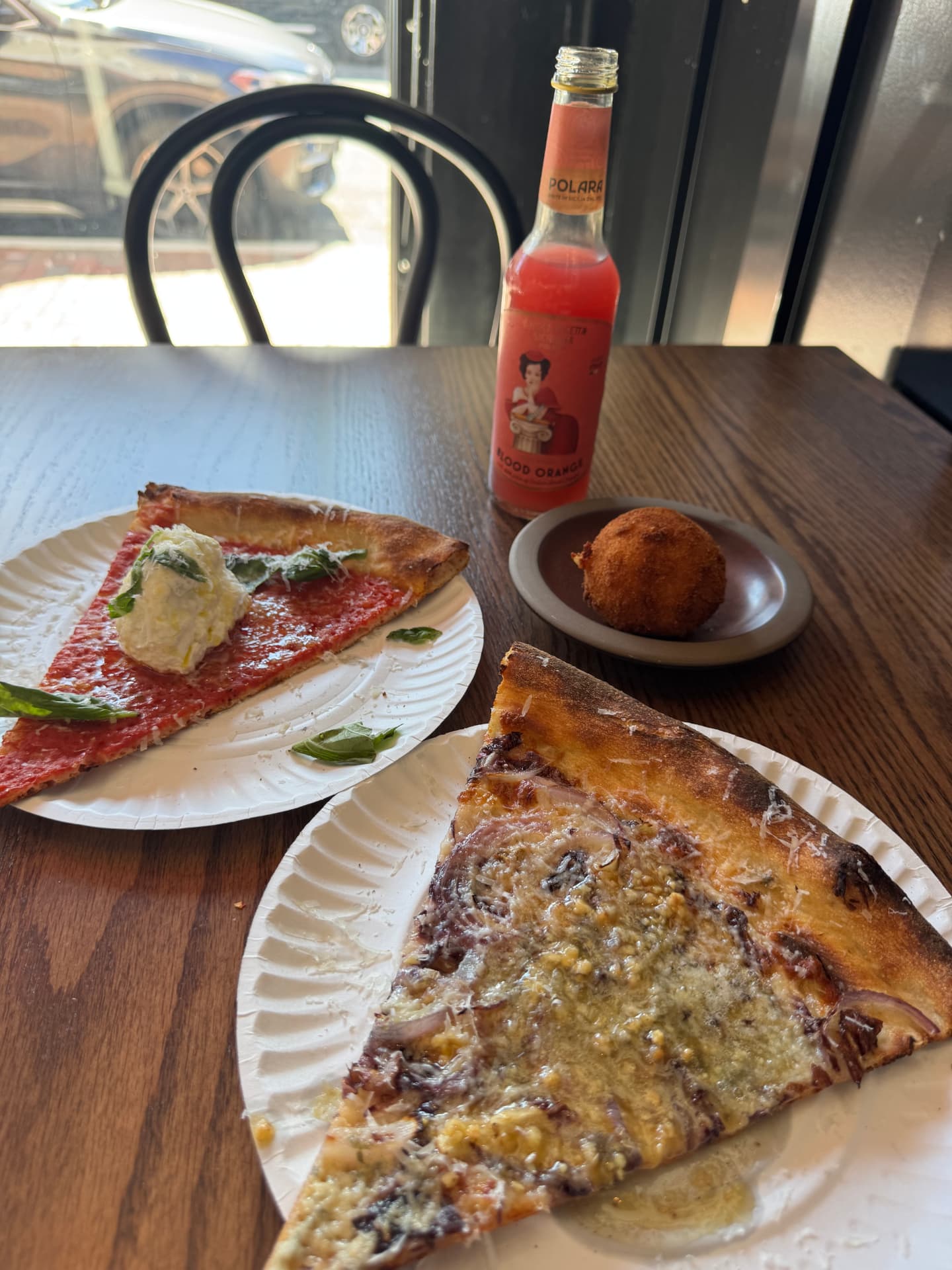 Ricotta tomato and Gricia slices, a carbonara ball and blood-orange soda on Jennifer’s table at Pollara