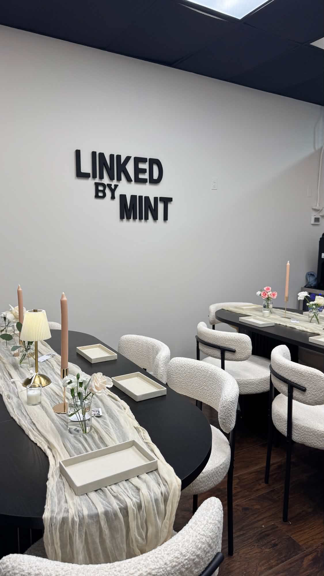 Private party room with long tables, flowers and upholstered chairs at Linked by Mint in Red Bank