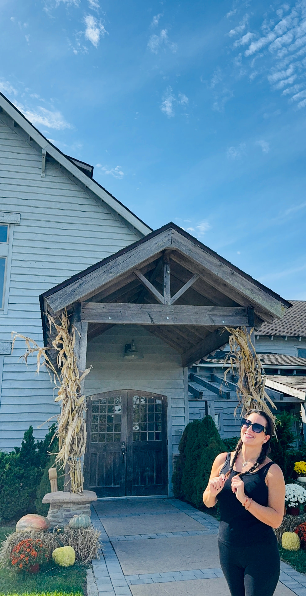 Jennifer Nangano outside the rustic entrance to Laurita Winery, decorated for fall