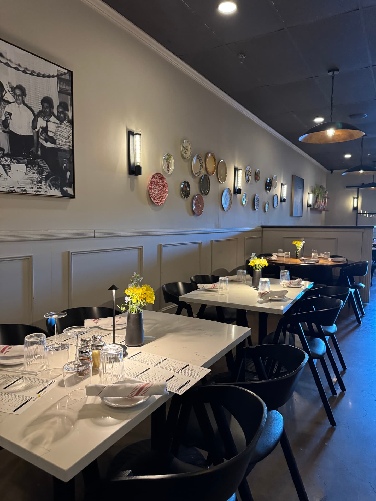 Mezza Luna's dining room, set tables and decorative plates on the wall